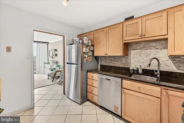 a kitchen with stainless steel appliances granite countertop a refrigerator and a sink