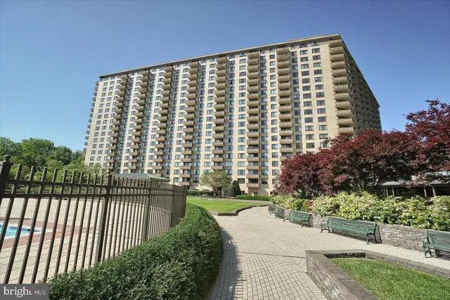 a view of a swimming pool with lawn chairs wooden floor and fence