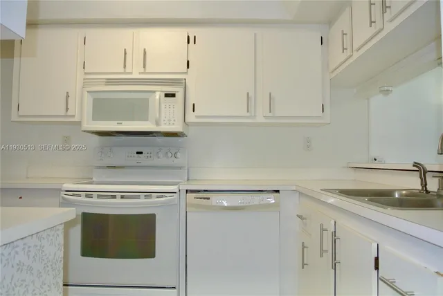 a kitchen with a refrigerator sink and cabinets