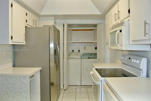 a kitchen with granite countertop white cabinets and a stove