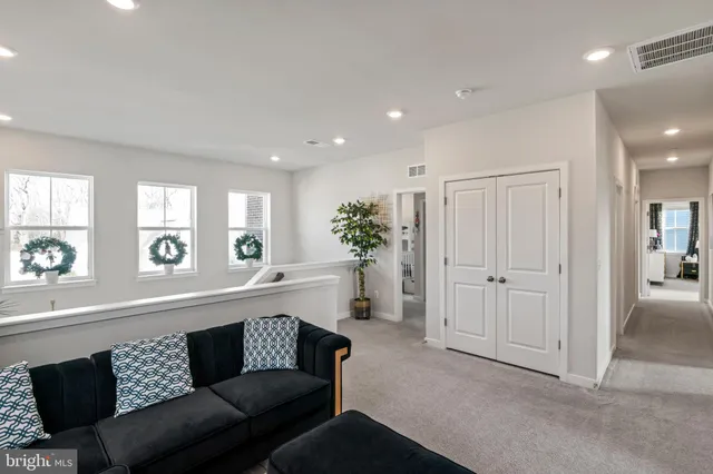 a view of a hallway with wooden floor and a potted plant