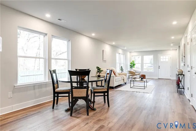 a view of a a dining room with furniture window and wooden floor