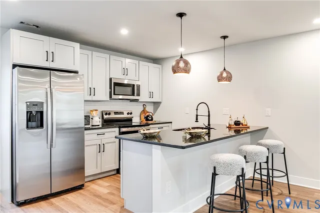 a kitchen with stainless steel appliances granite countertop a sink a stove a refrigerator and cabinets