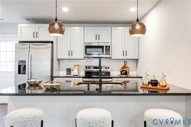 a kitchen with stainless steel appliances a stove a sink and cabinets