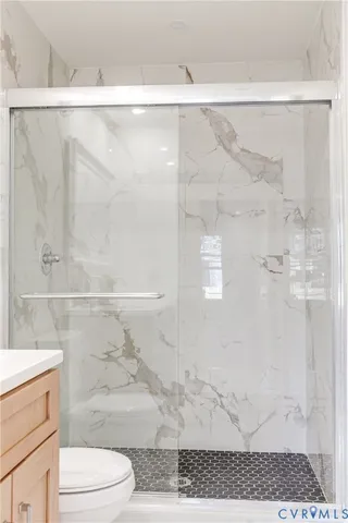 a bathroom with a shower a toilet and a sink