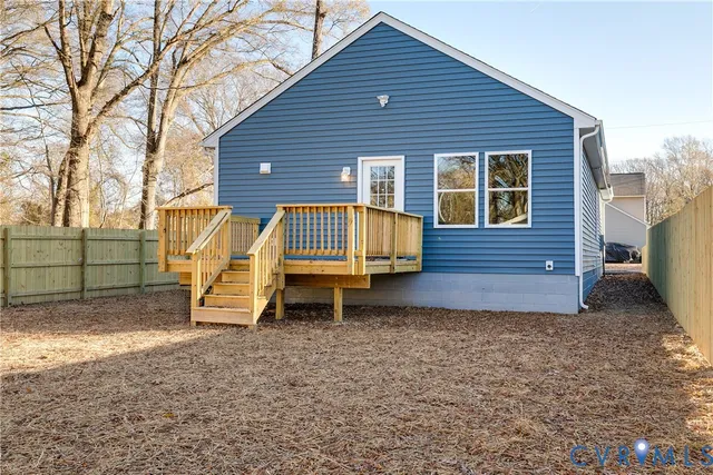 a view of a house with a yard and wooden fence