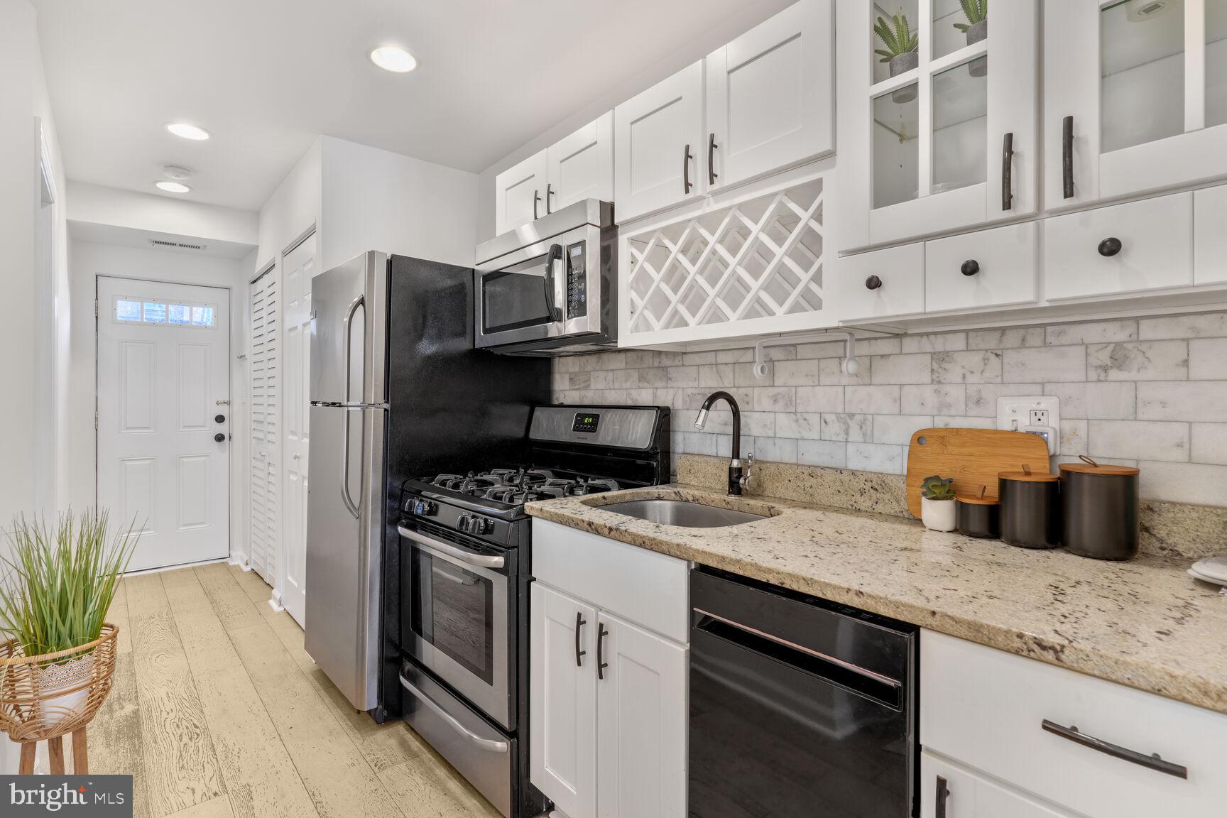 1268 16th Street Northeast Washington, DC 20002 - Photo 6 of 17 a kitchen with stainless steel appliances granite countertop a sink stove and refrigerator