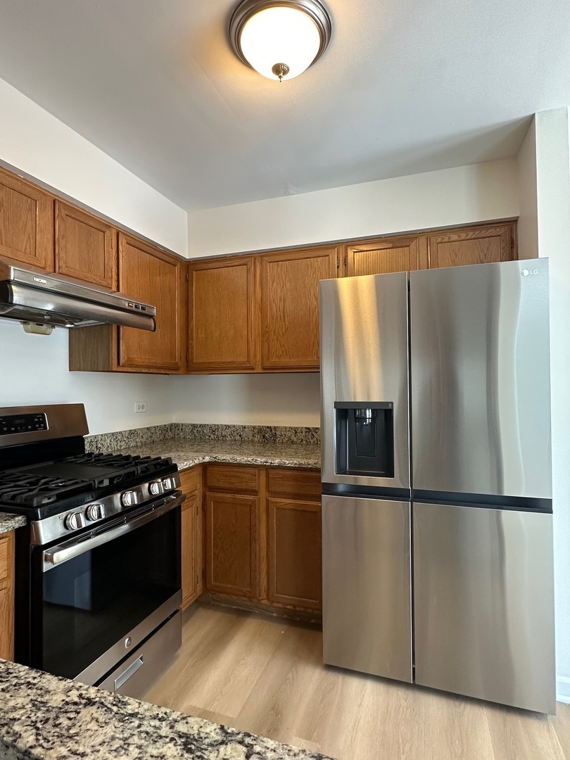 1712 Napoleon Drive Naperville, IL 60565 - Photo 8 of 19 a kitchen with granite countertop a refrigerator stove and microwave
