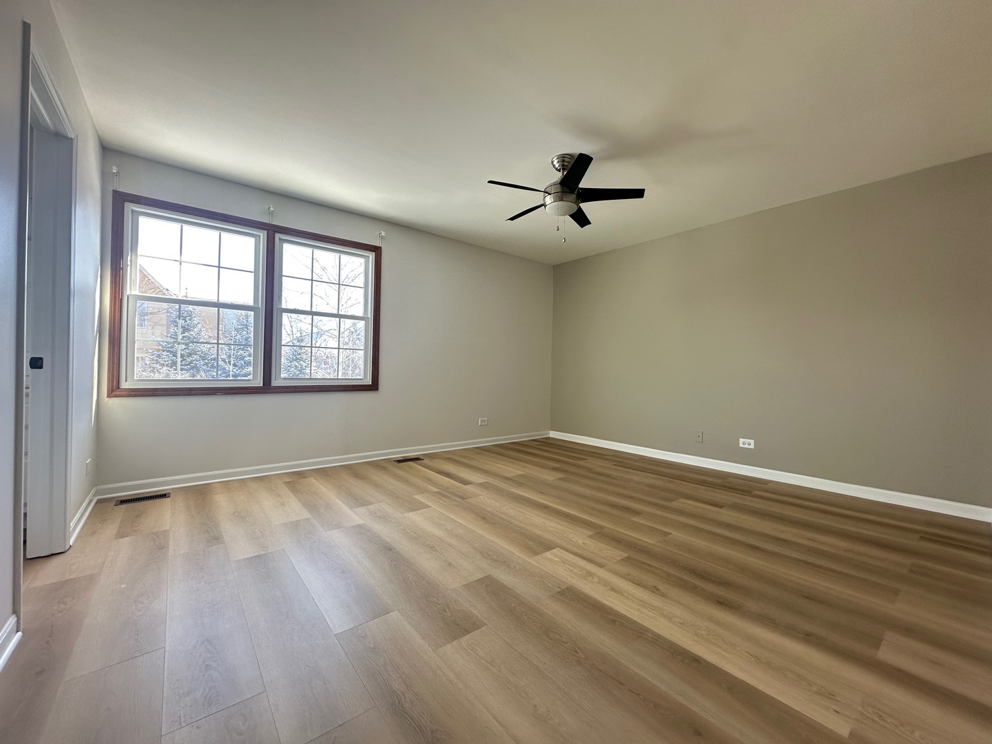 1712 Napoleon Drive Naperville, IL 60565 - Photo 10 of 19 a view of an empty room with a window and wooden floor