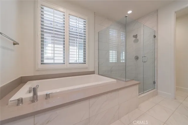 a spacious bathroom with a tub shower and mirror