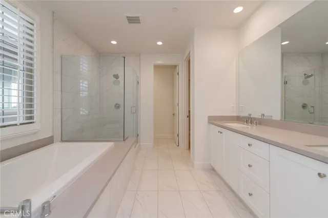 a spacious bathroom with a granite countertop sink a mirror a shower and a bathtub