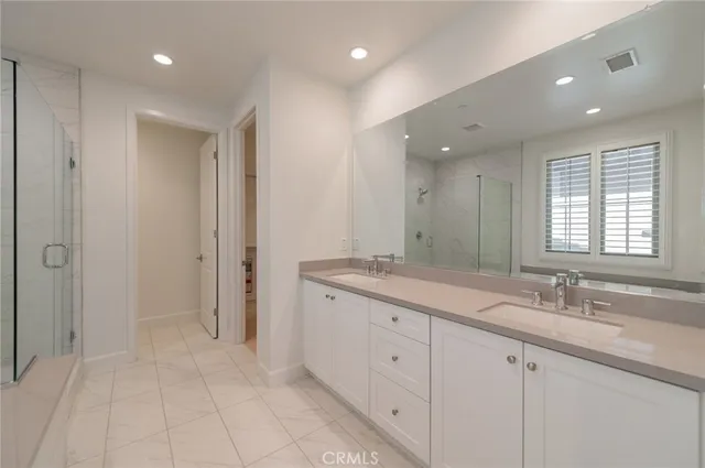 a spacious bathroom with a granite countertop sink a mirror and a shower