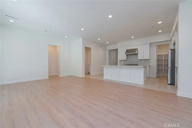 a view of a kitchen with a sink and dishwasher a refrigerator with wooden floor