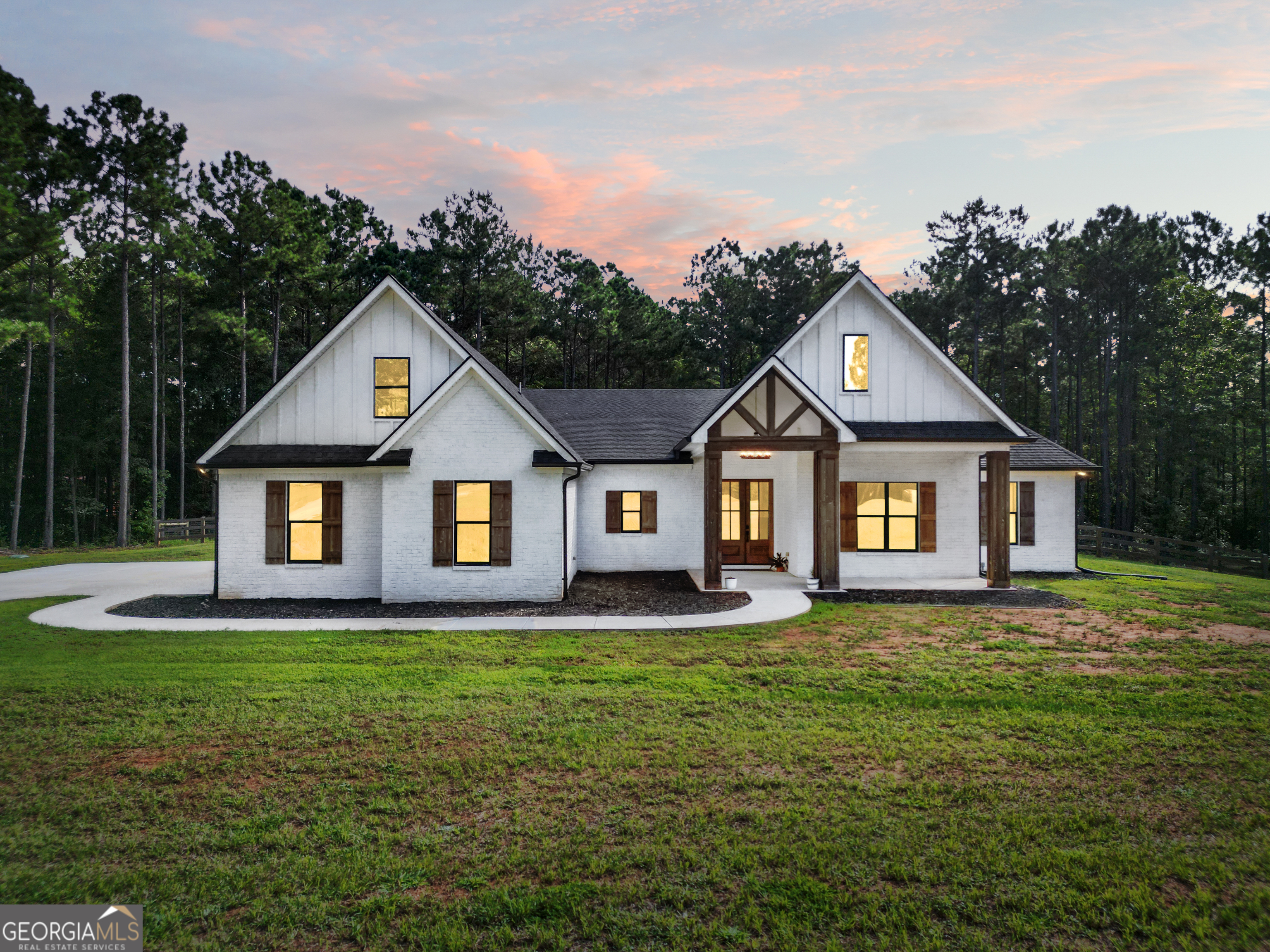 a front of a house with a yard and trees