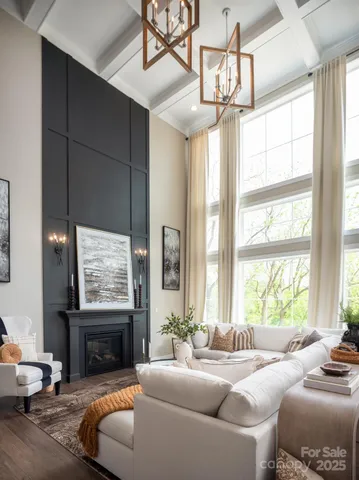 a living room with furniture a chandelier and a large window
