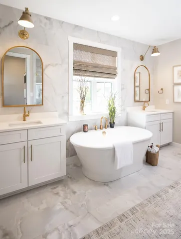 a spacious bathroom with a double vanity sink mirror and bathtub