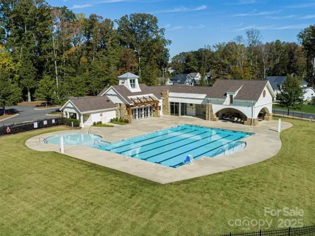 a view of a swimming pool with lawn chairs under an umbrella