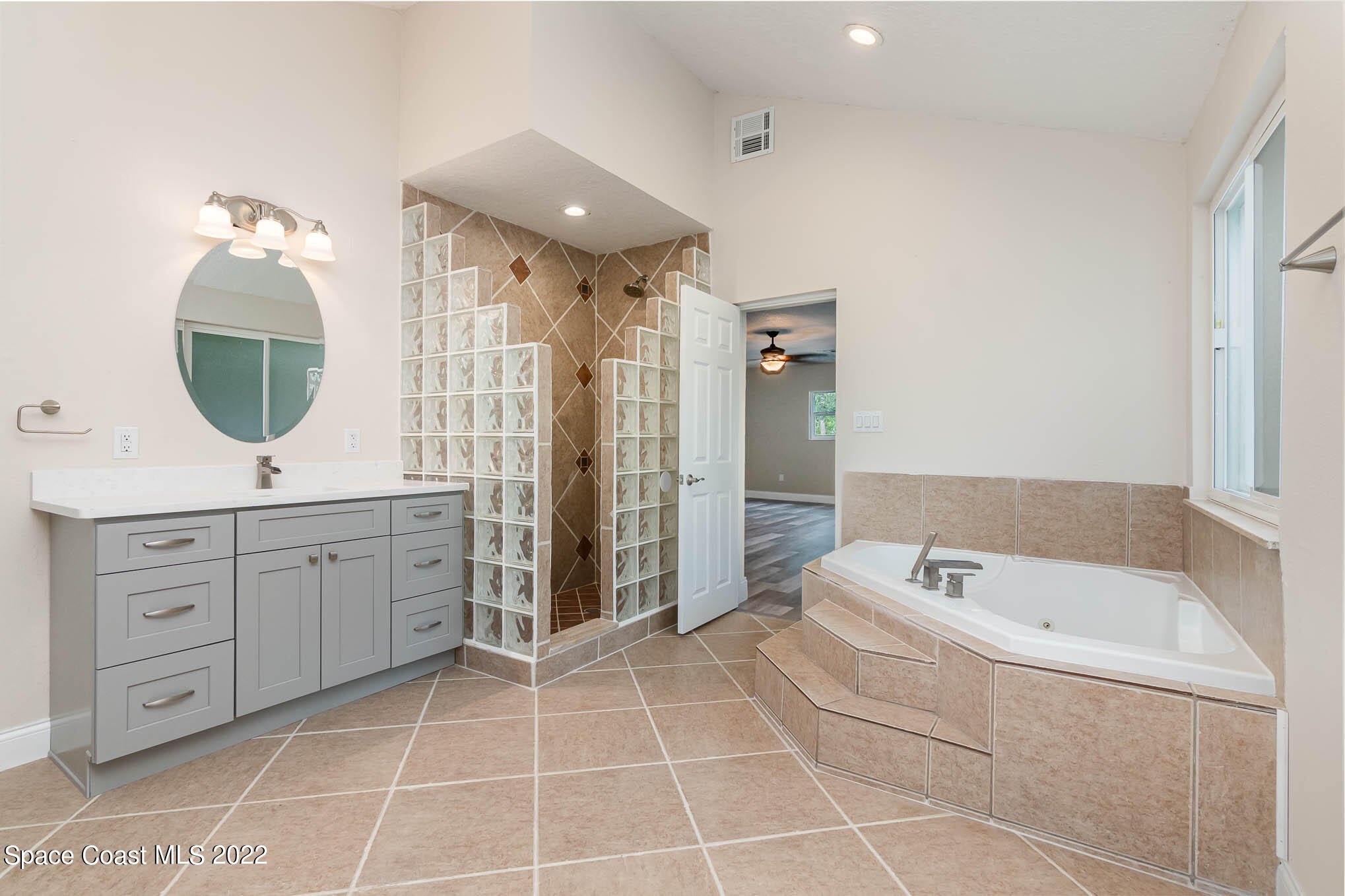 2380 Friday Road Cocoa, FL 32926 - Photo 20 of 30 a spacious bathroom with a double vanity sink a mirror and a bathtub