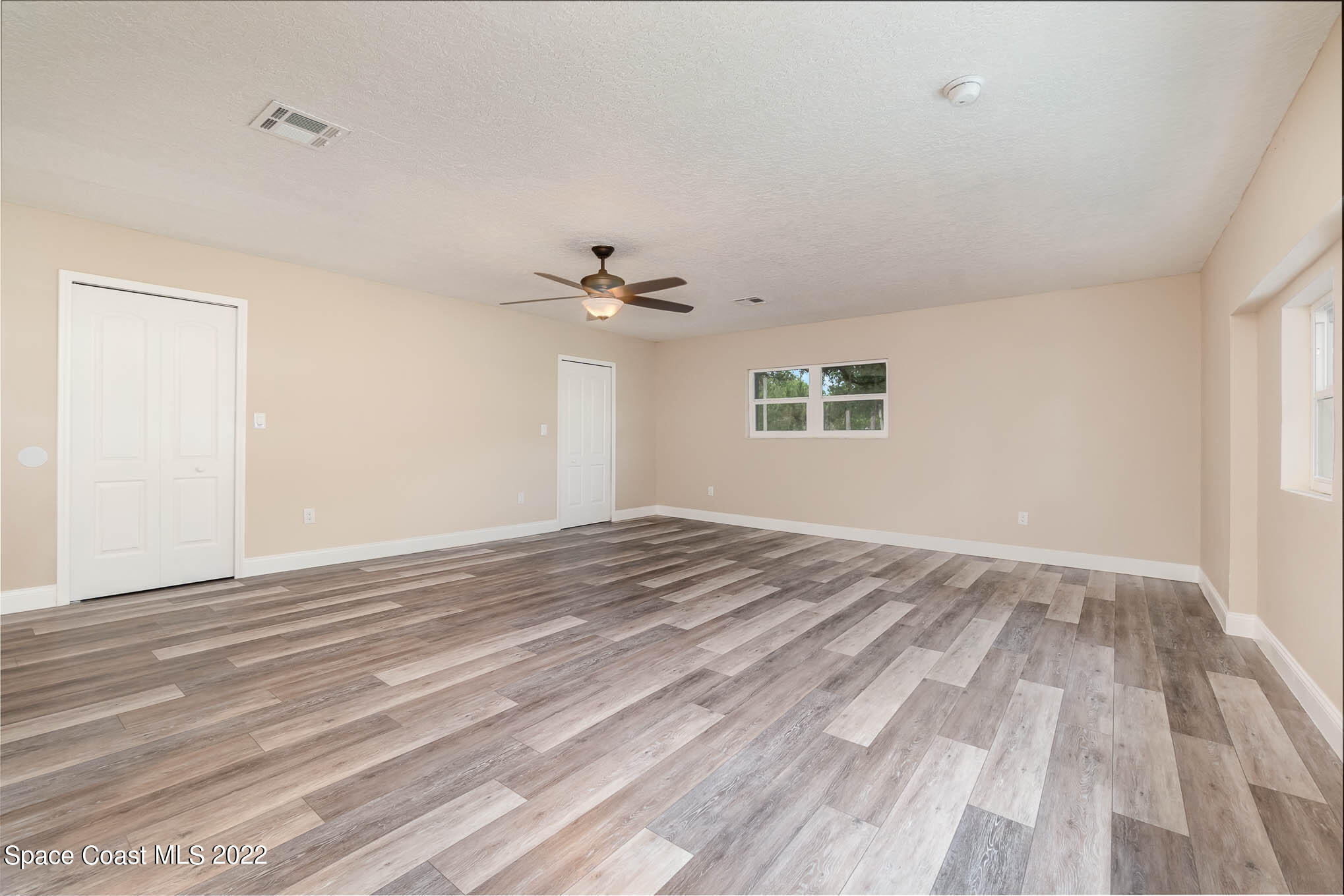 2380 Friday Road Cocoa, FL 32926 - Photo 22 of 30 a view of empty room with wooden floor and fan