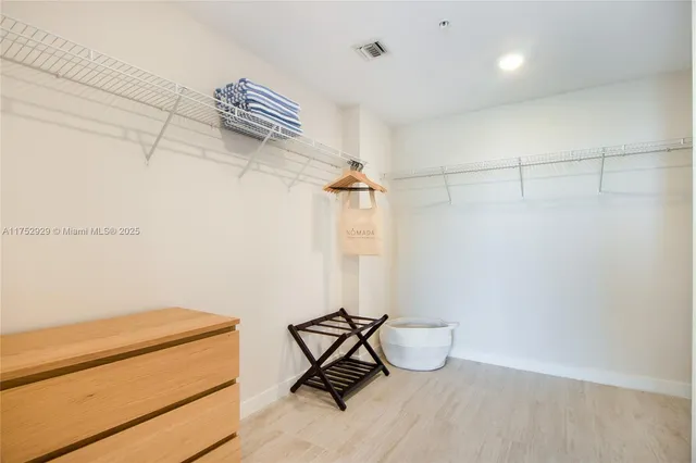 a room with a walk in closet and wooden floor