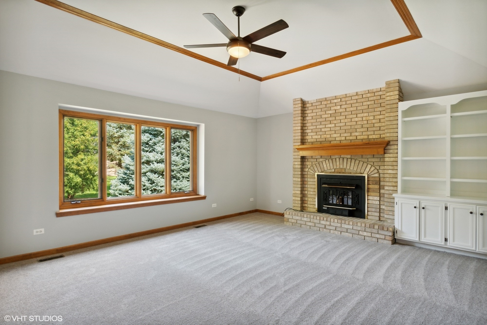 2772 Freeland Circle Naperville, IL 60564 - Photo 10 of 33 an empty room with windows fireplace and a ceiling fan