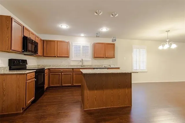 a kitchen with stainless steel appliances granite countertop a stove a sink and a microwave