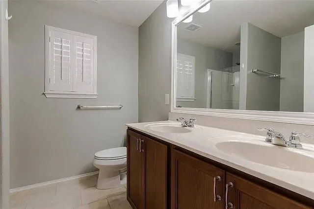 a bathroom with a granite countertop sink a toilet and a mirror