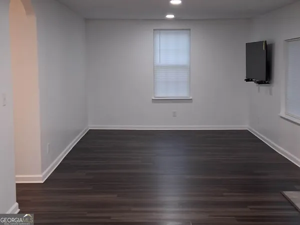 a room with wooden floor and flat screen tv