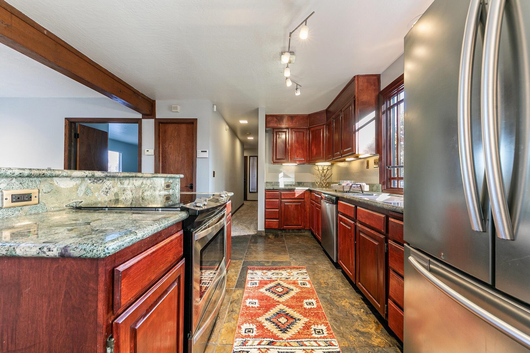10806 Manchester Drive Truckee, CA 96161 - Photo 6 of 28 a kitchen with stainless steel appliances granite countertop a stove and a refrigerator