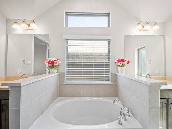 a bathroom with a tub sink and mirror