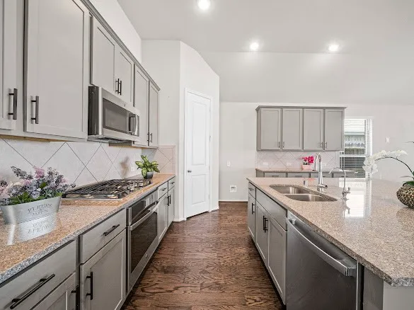 a kitchen with stainless steel appliances granite countertop a sink stove and cabinets
