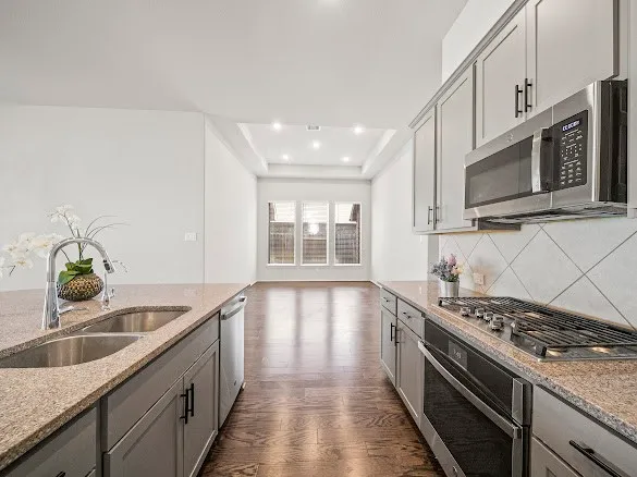 a kitchen with stainless steel appliances granite countertop a sink stove and microwave