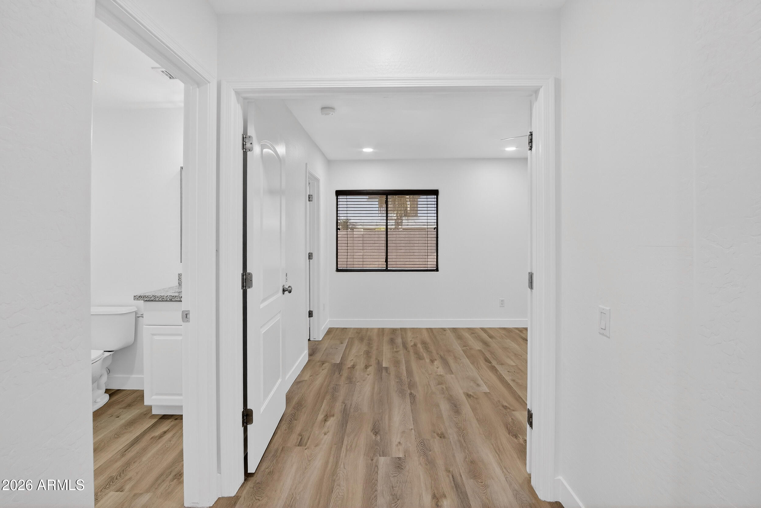 43620 West Cowpath Road Maricopa, AZ 85138 - Photo 7 of 60 a view of a hallway with wooden floor and a bathroom