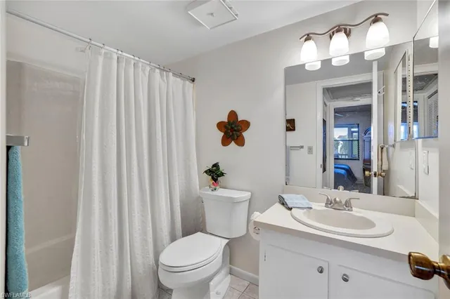 a bathroom with a toilet a sink a mirror a vanity and shower