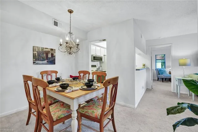 a dining room with furniture a chandelier and wooden floor