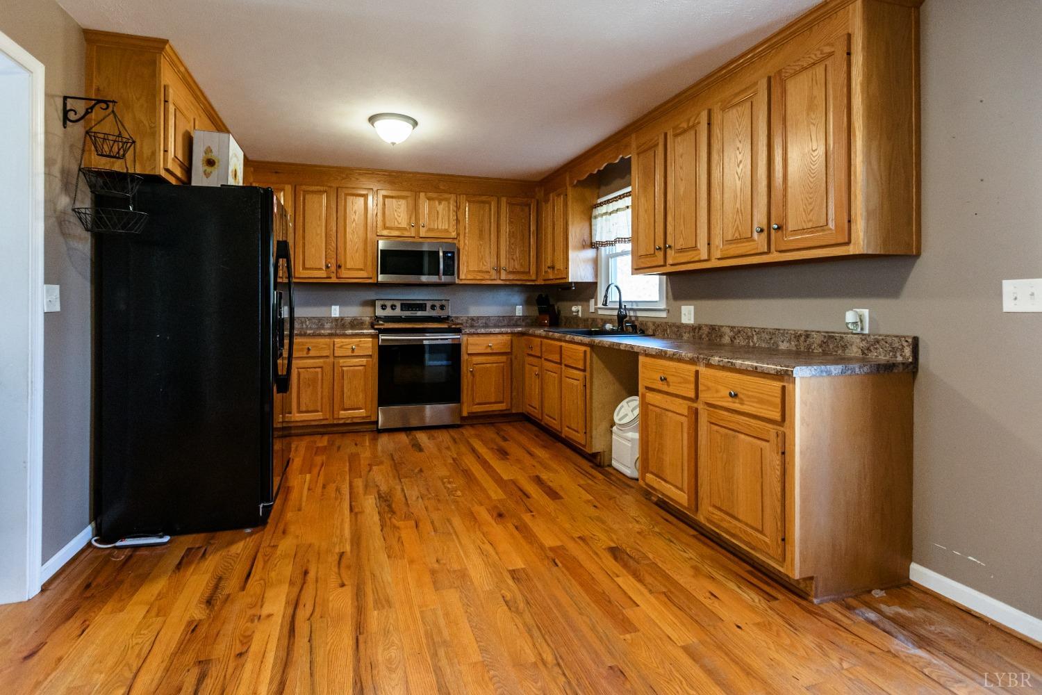4945 Hixburg Road Pamplin, VA 23958 - Photo 5 of 27 a kitchen with stainless steel appliances granite countertop a refrigerator a sink dishwasher a stove with wooden cabinets and floor
