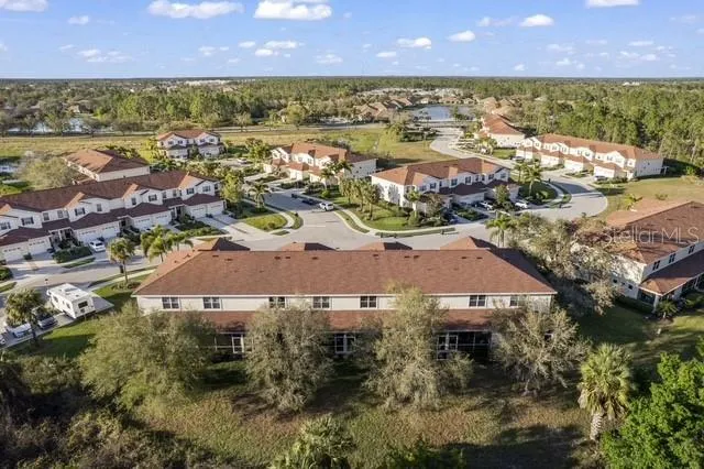an aerial view of residential houses with outdoor space and lake view