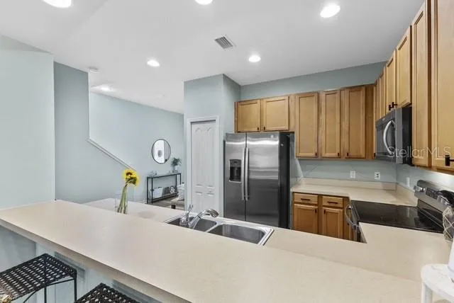 a kitchen with stainless steel appliances a sink a stove a refrigerator a washer dryer and a refrigerator