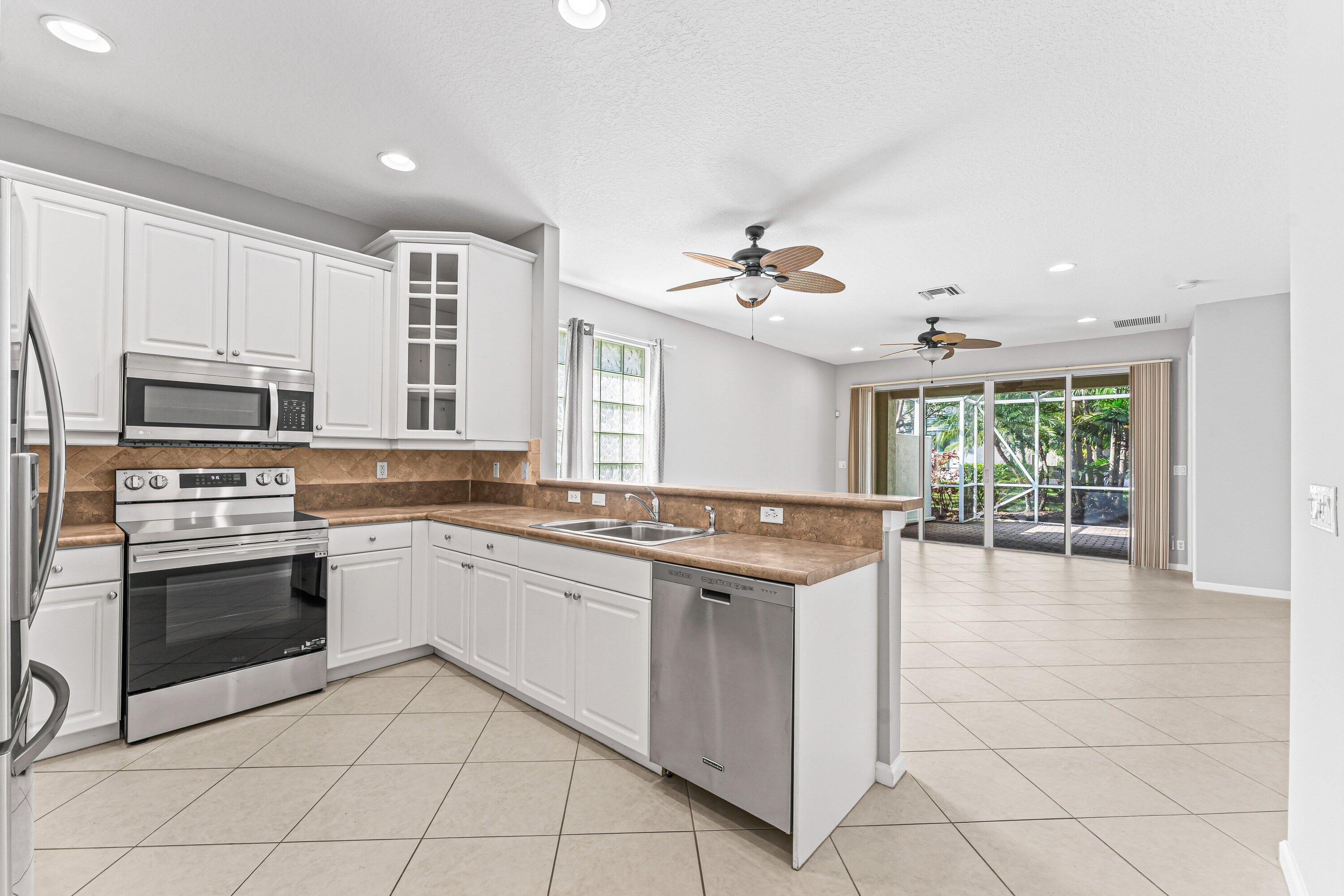 443 Belle Grove Lane West Palm Beach, FL 33411 - Photo 11 of 29 a kitchen with stainless steel appliances granite countertop a stove and more cabinets