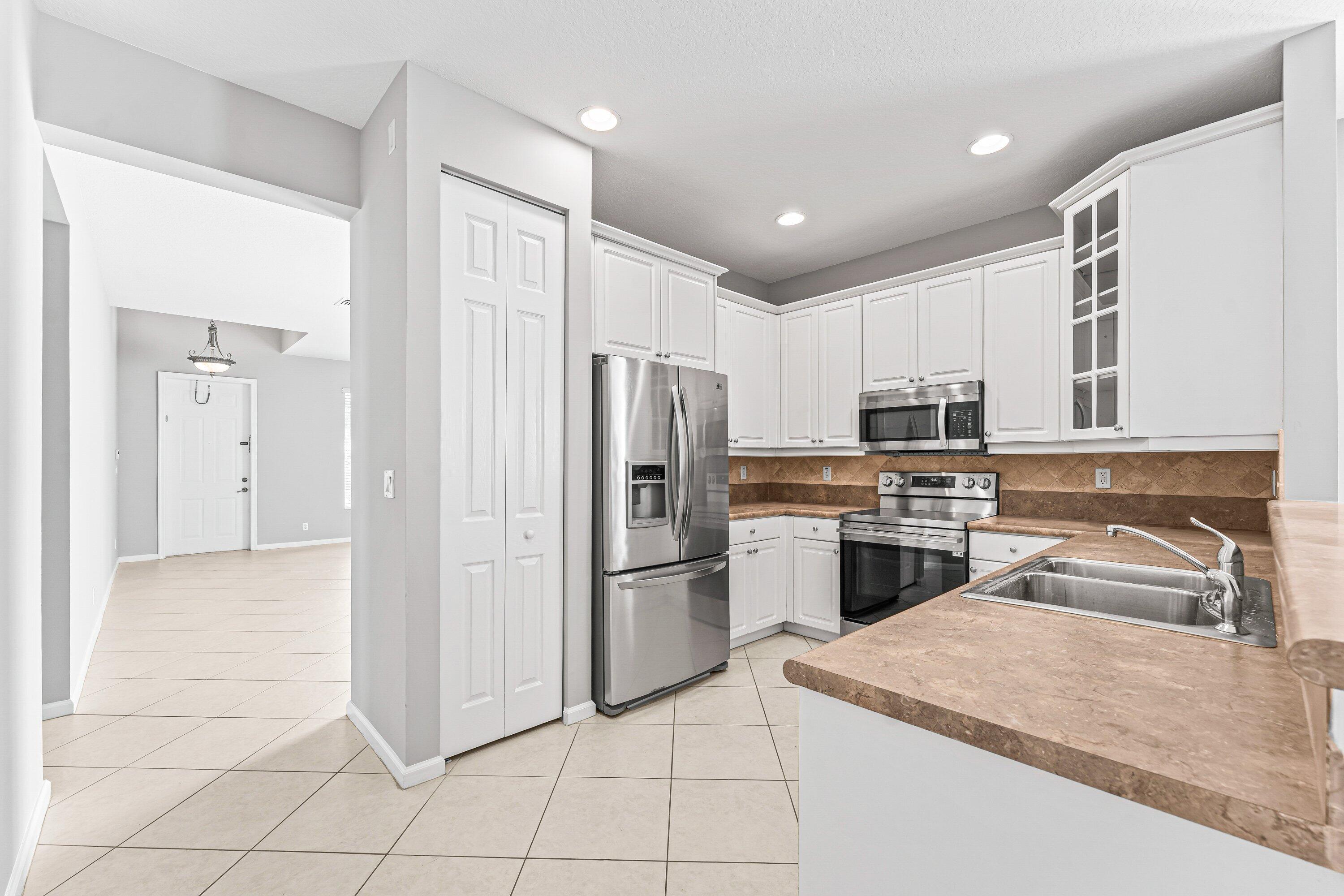 443 Belle Grove Lane West Palm Beach, FL 33411 - Photo 12 of 29 a kitchen with stainless steel appliances granite countertop a refrigerator and a sink