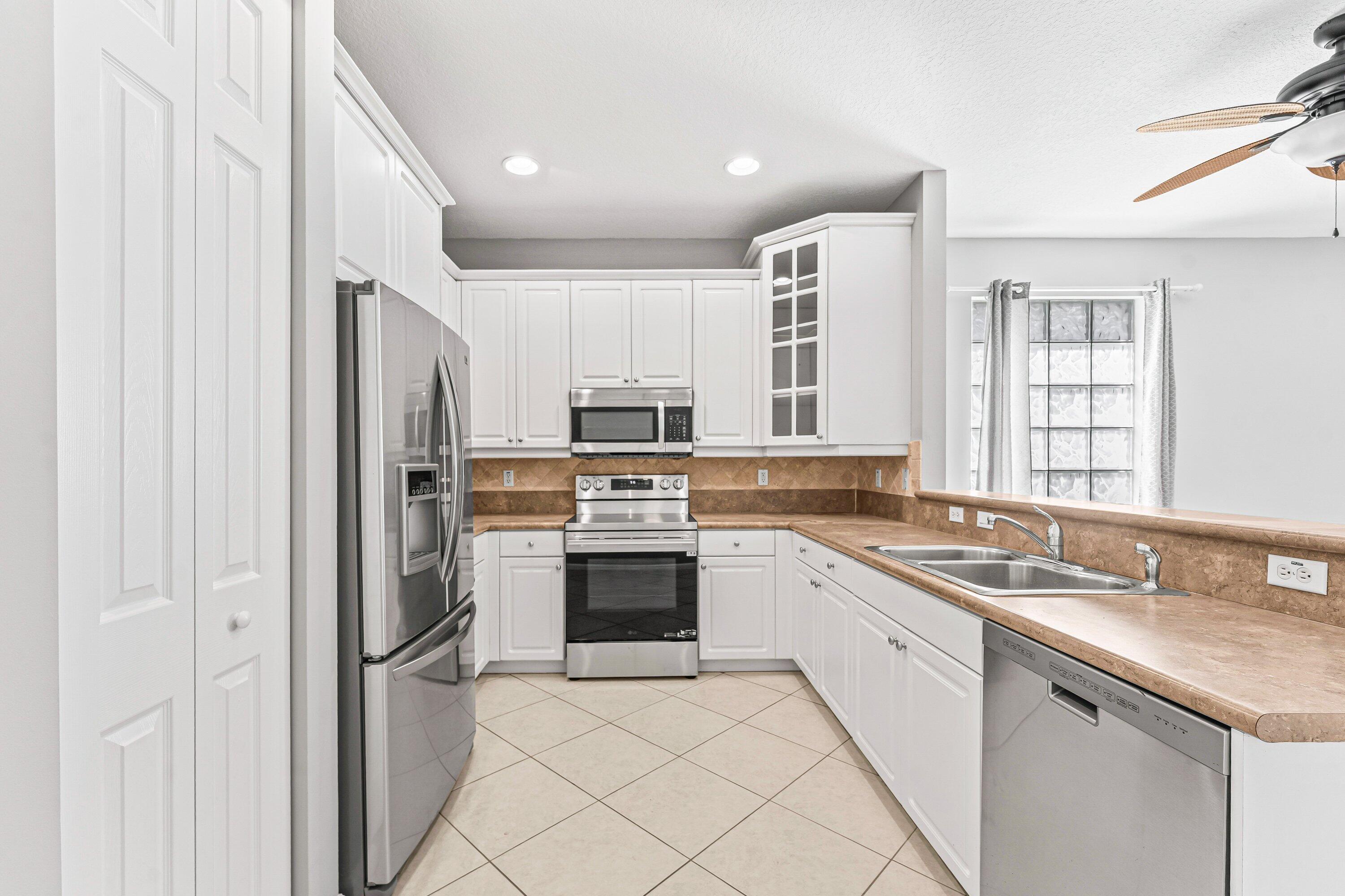 443 Belle Grove Lane West Palm Beach, FL 33411 - Photo 13 of 29 a kitchen with a sink stove and refrigerator