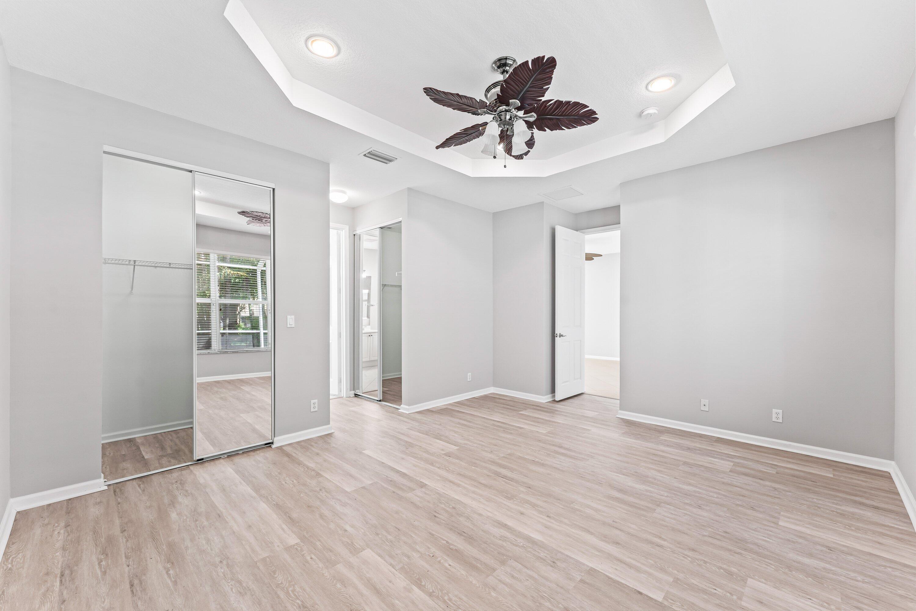 443 Belle Grove Lane West Palm Beach, FL 33411 - Photo 21 of 29 a view of an empty room with wooden floor and a ceiling fan