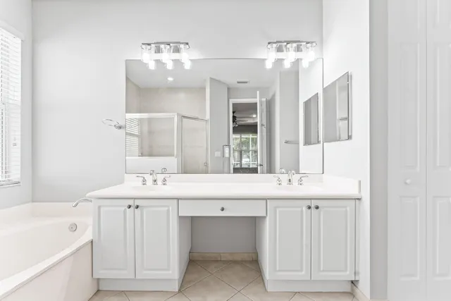 a bathroom with a tub sink shower and mirror