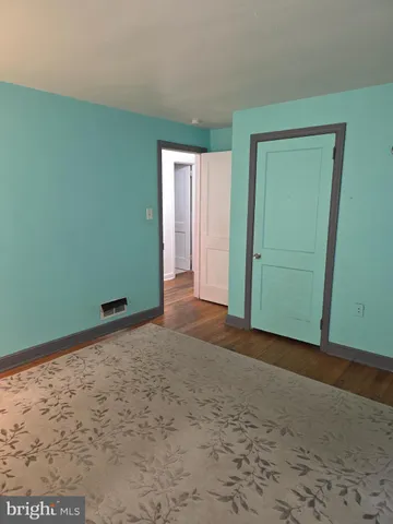 a view of a room with wooden floor and windows