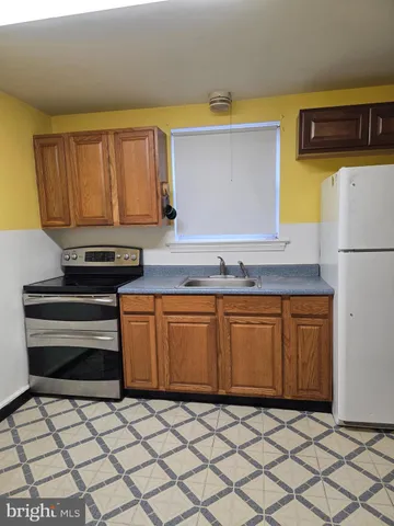 a kitchen with granite countertop a refrigerator a stove a sink and dishwasher