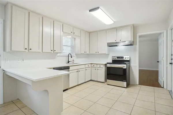 a kitchen with stainless steel appliances a sink stove and cabinets