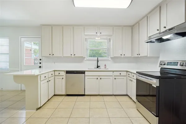 a kitchen with a sink stove and cabinets