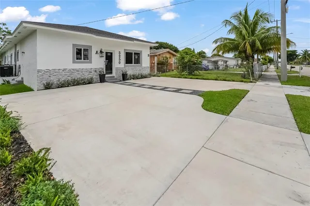 a front view of a house with a yard and potted plants