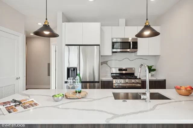 a kitchen with a refrigerator a stove a sink and a dining table