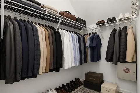 a view of walk in closet with clothes and shoes